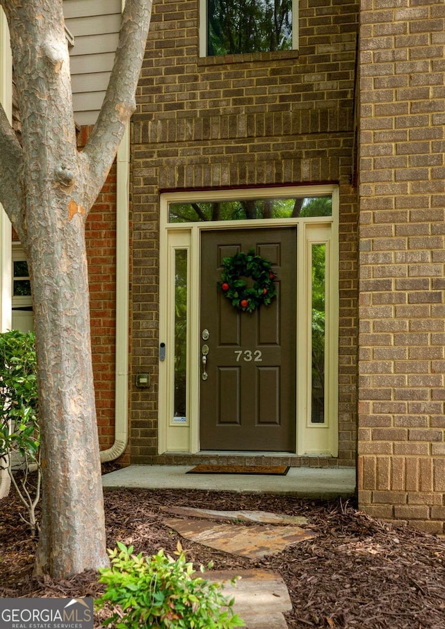 property entrance featuring brick siding