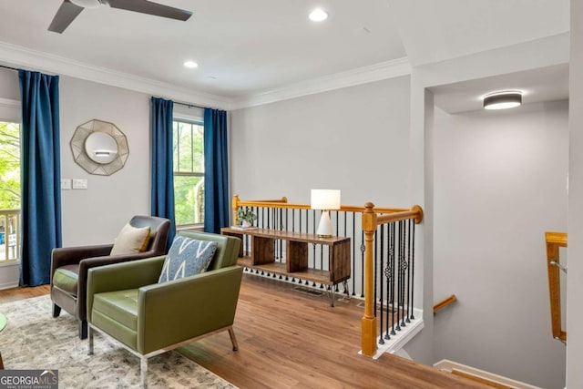living area with wood finished floors, a wealth of natural light, and an upstairs landing