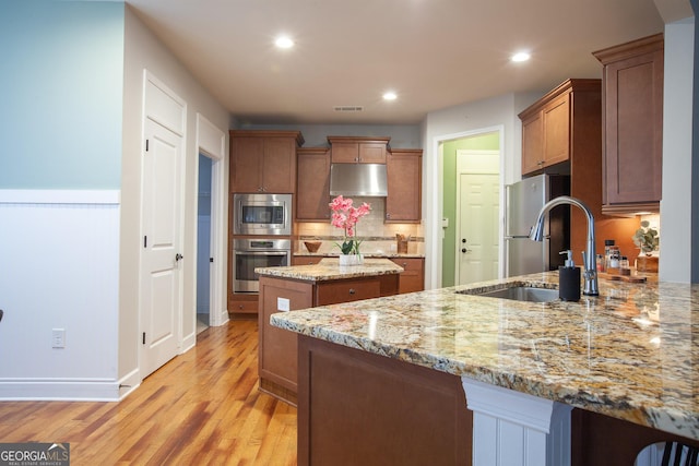 3508 Blue Spruce Ct SW, Gainesville, GA 30504 - kitchen featuring appliances with stainless steel finishes, under cabinet range hood, a sink, a kitchen island, and light wood finished floors