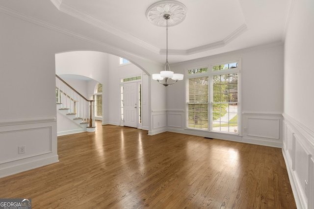 679 Gold Valley Pass, Canton, GA 30114 - unfurnished dining area featuring crown molding, arched walkways, wood finished floors, and a notable chandelier
