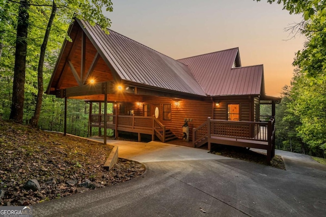 433 Spruce Cir, Mineral Bluff, GA 30559 - back of property at dusk with covered porch, a wooden deck, faux log siding, and metal roof