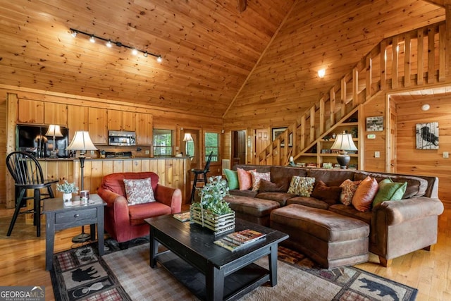 433 Spruce Cir, Mineral Bluff, GA 30559 - living room featuring wood walls, rail lighting, stairway, high vaulted ceiling, and light wood-style flooring