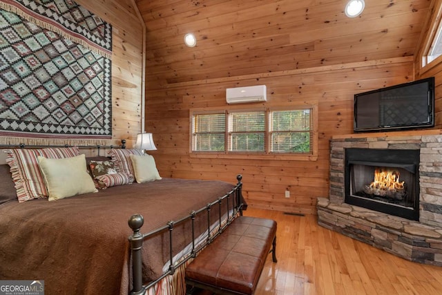 433 Spruce Cir, Mineral Bluff, GA 30559 - bedroom featuring a fireplace, high vaulted ceiling, an AC wall unit, light wood finished floors, and wooden walls