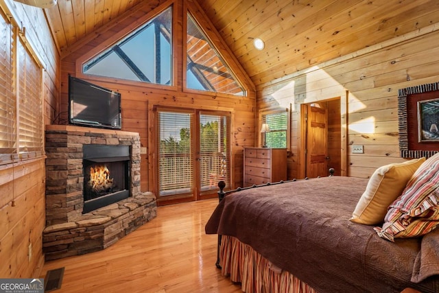 433 Spruce Cir, Mineral Bluff, GA 30559 - bedroom featuring access to outside, a fireplace, wood walls, light wood-type flooring, and visible vents