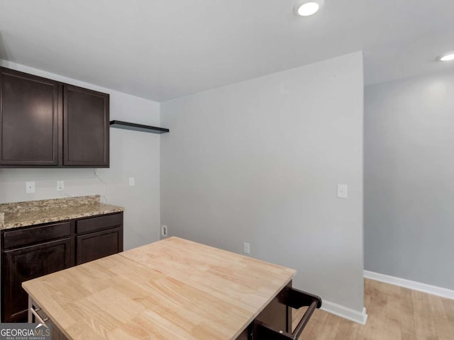 kitchen featuring recessed lighting, baseboards, dark brown cabinetry, and light wood finished floors
