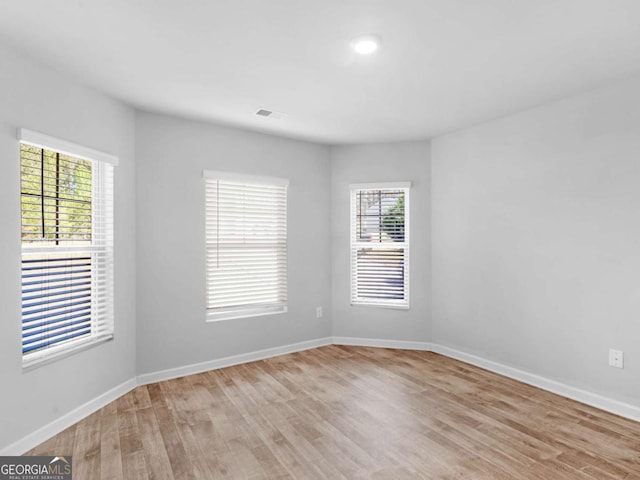 empty room with baseboards and light wood-style flooring