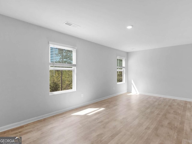 empty room with baseboards, recessed lighting, light wood-style flooring, and visible vents