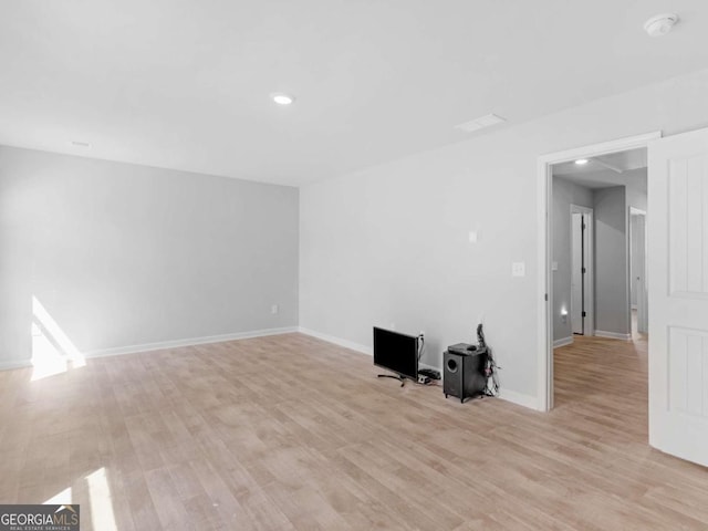 unfurnished living room with recessed lighting, baseboards, and light wood finished floors