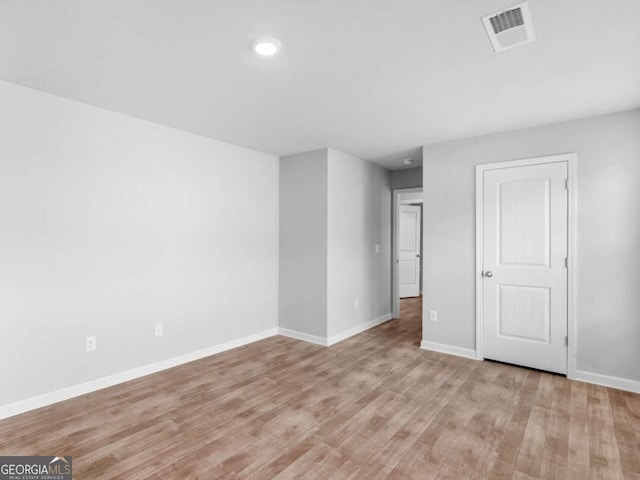 unfurnished room featuring baseboards, light wood-style flooring, and visible vents