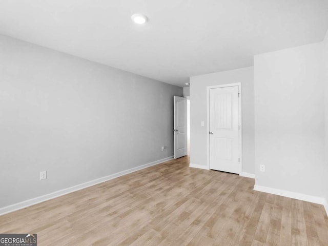 empty room with baseboards, recessed lighting, and light wood-style flooring