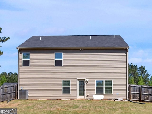 back of house featuring a fenced backyard and a yard