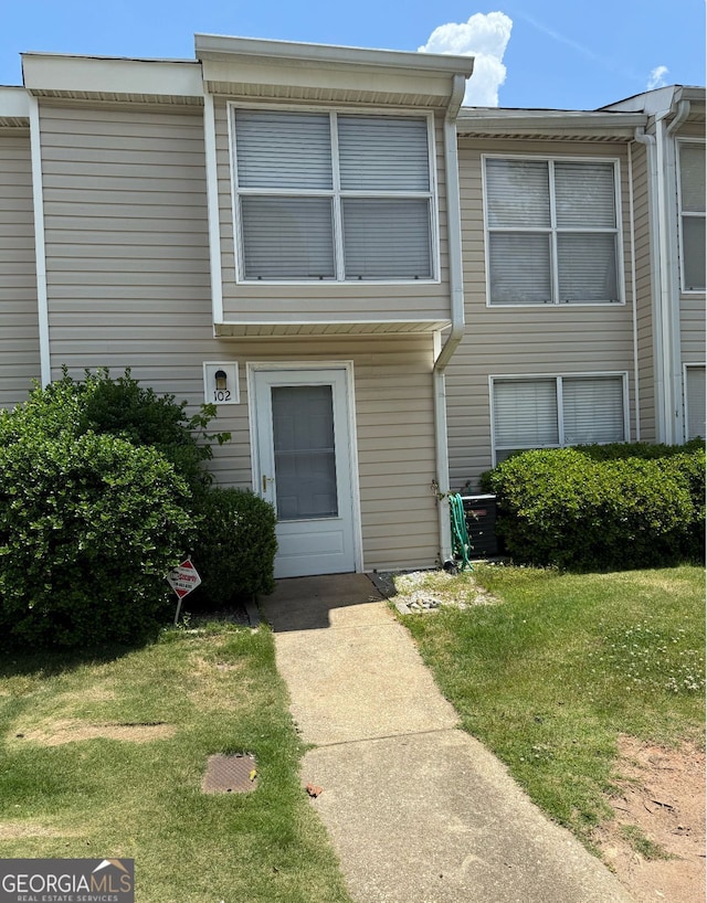 townhome / multi-family property featuring a front yard