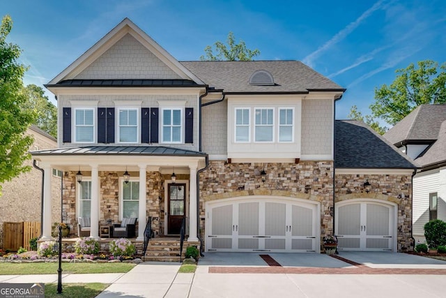 craftsman-style house featuring a porch, a standing seam roof, stone siding, driveway, and roof with shingles