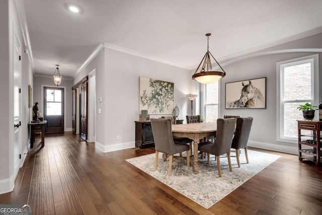 dining area featuring dark wood-type flooring, baseboards, and crown molding