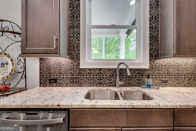 kitchen featuring a sink, stainless steel dishwasher, tasteful backsplash, and dark brown cabinetry