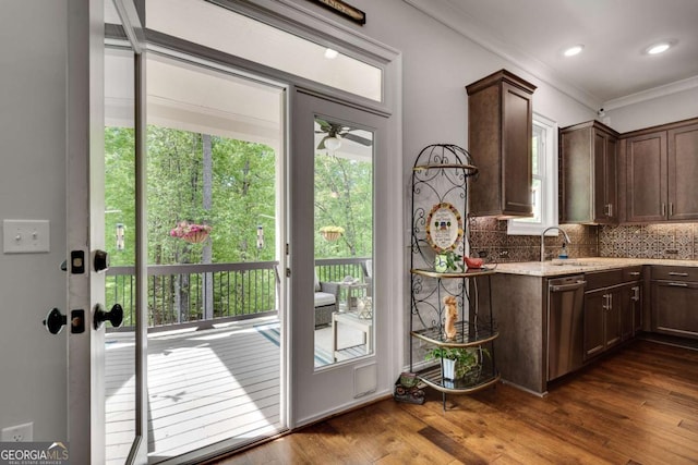 doorway to outside with ornamental molding, dark wood-type flooring, a sink, and a ceiling fan