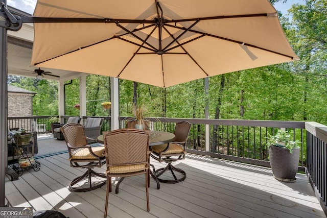 deck featuring outdoor dining space and a ceiling fan