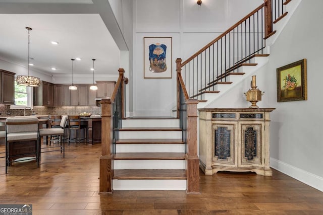 stairway featuring hardwood / wood-style flooring, baseboards, and recessed lighting