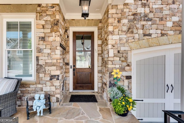 view of exterior entry featuring stone siding and radiator heating unit