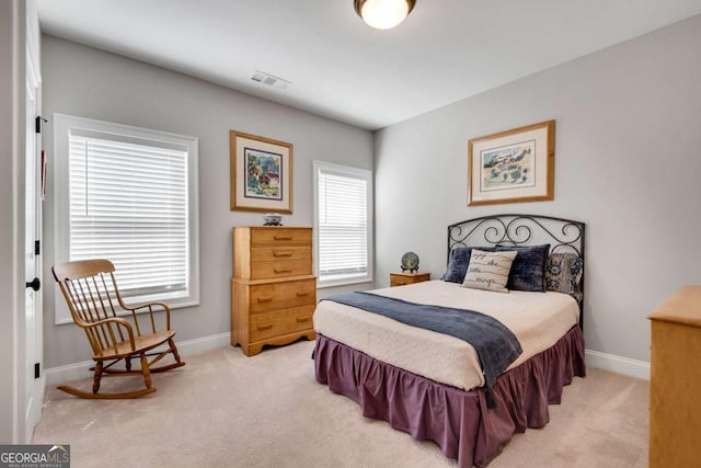 bedroom with light colored carpet and baseboards