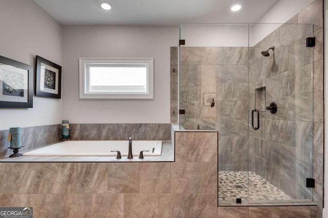 bathroom featuring a shower stall and a garden tub