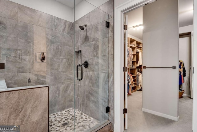 full bath featuring a stall shower and a walk in closet