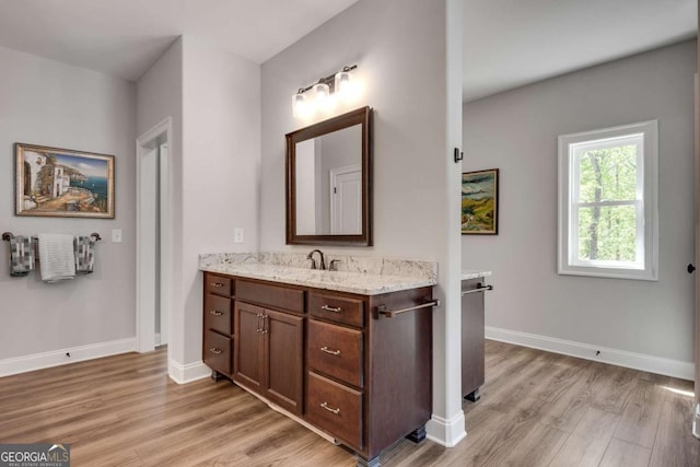 bathroom with wood finished floors, vanity, and baseboards