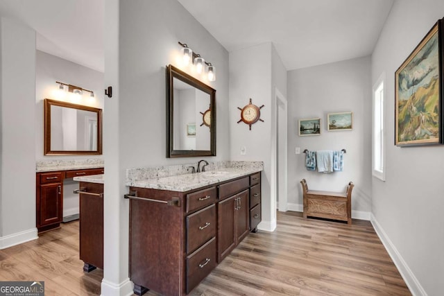 bathroom with wood finished floors, vanity, and baseboards