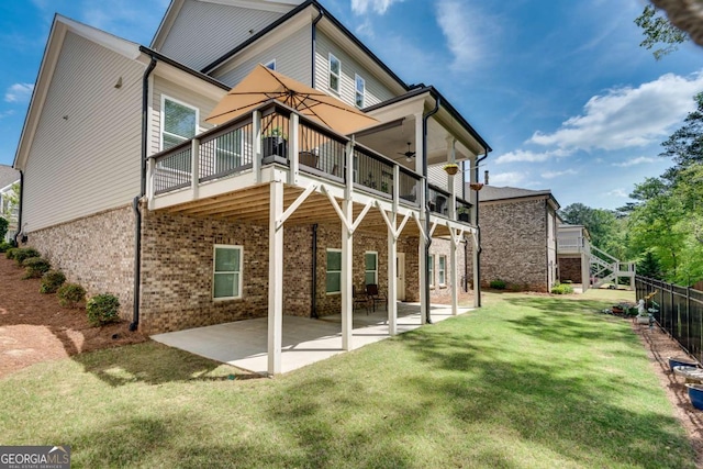 back of property with ceiling fan, a patio area, brick siding, and a deck