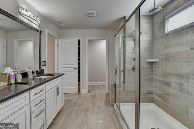 6413 Maple Park Ln, Hoschton, GA 30548 - full bath with vanity, baseboards, a shower stall, wood finished floors, and visible vents