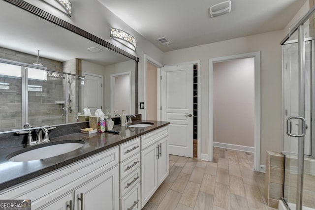 6413 Maple Park Ln, Hoschton, GA 30548 - full bathroom featuring visible vents, a sink, baseboards, and a shower stall
