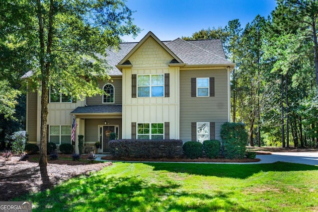 craftsman house featuring a shingled roof, board and batten siding, and a front lawn