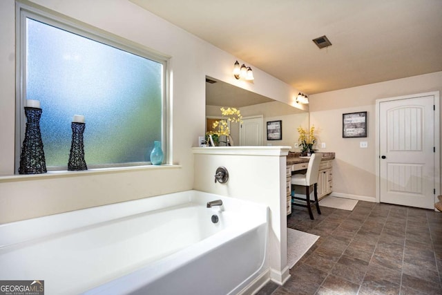 bathroom with visible vents, plenty of natural light, a bath, and vanity