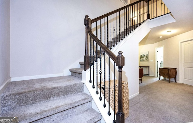 stairs featuring baseboards and carpet flooring