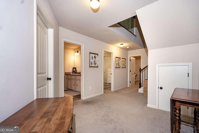 hall with baseboards, light carpet, and stairway
