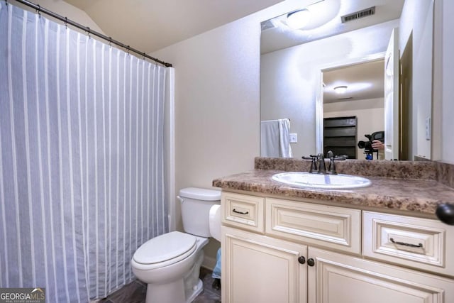 bathroom featuring vanity, visible vents, and toilet