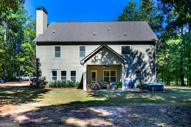 rear view of house featuring a chimney, an outdoor living space, a ceiling fan, a patio area, and a yard