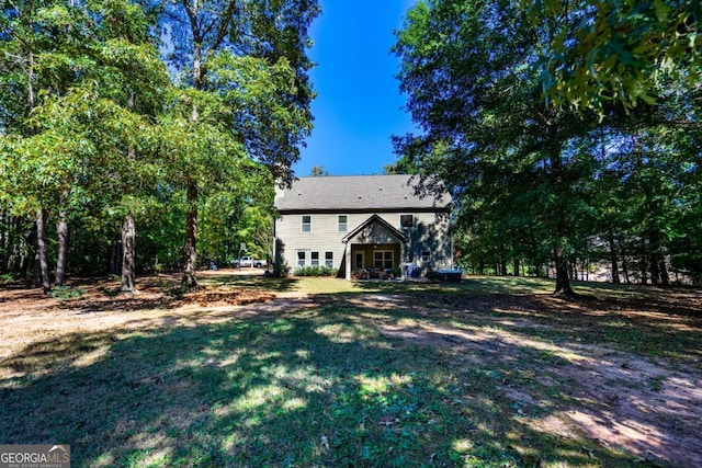 rear view of house featuring a lawn
