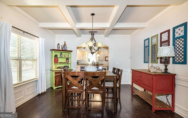 dining area with an inviting chandelier, dark wood-style flooring, and a decorative wall