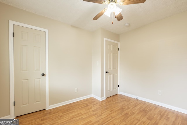 unfurnished bedroom with baseboards, a ceiling fan, and light wood-style flooring