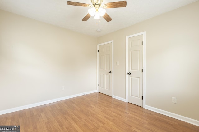 spare room with baseboards, a ceiling fan, and light wood-type flooring