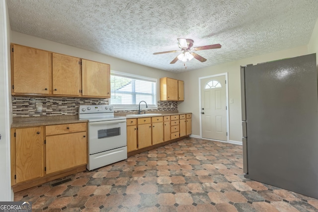 kitchen with a ceiling fan, tasteful backsplash, a sink, freestanding refrigerator, and white electric range oven