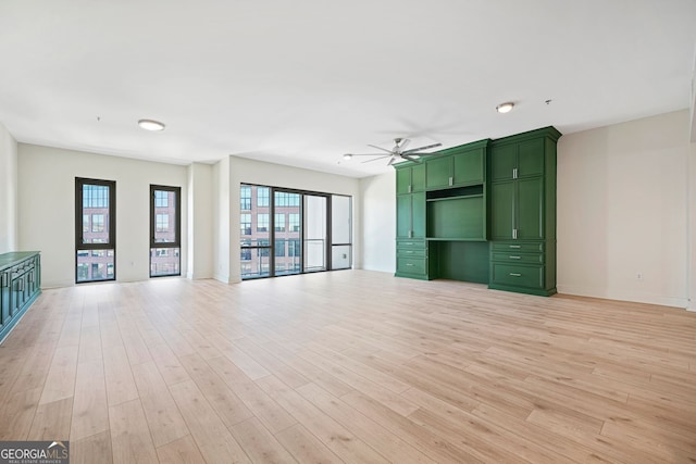 1100 Howell Mill Rd NW Unit 505, Atlanta, GA 30318 - unfurnished living room with a ceiling fan, baseboards, and light wood finished floors