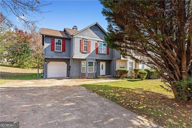 traditional-style home featuring an attached garage, driveway, a chimney, and a front yard