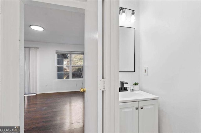 bathroom featuring baseboards, wood finished floors, and vanity
