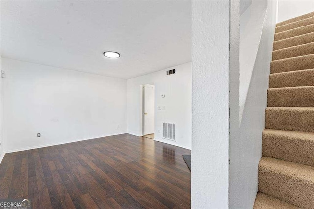 interior space with baseboards, visible vents, wood finished floors, and stairway