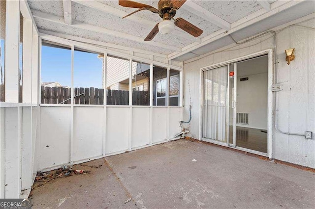 unfurnished sunroom featuring visible vents and ceiling fan