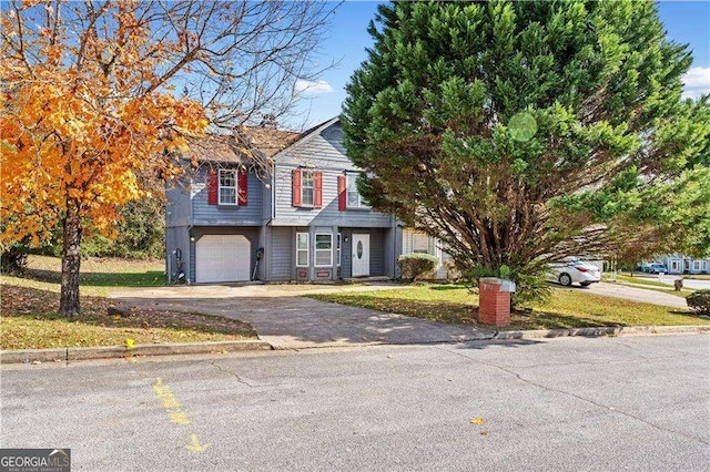 traditional-style home featuring an attached garage and aphalt driveway