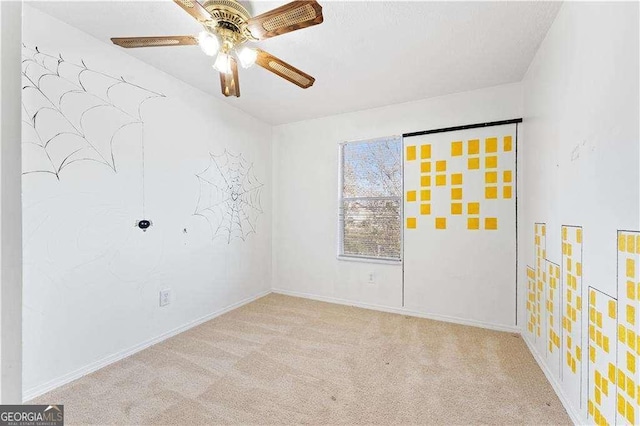 spare room featuring carpet floors, ceiling fan, and baseboards