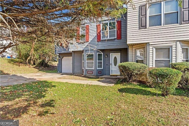 view of front of house with an attached garage, a front yard, and concrete driveway